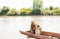 Tender caucasian fisherman receiving lick from faithful dog, while hugging pet and fishing in boat.