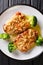 Tender chicken steaks fried with almonds with broccoli garnish closeup on a plate on the table. Vertical top view