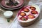 Tender curd casserole with plums and semolina, served with cinnamon and mint leaves on a wooden background