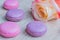 Tender french dessert macaroons with rose flower on wooden background