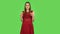 Tender girl in red dress is clapping her hands indifferent. Green screen