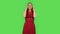 Tender girl in red dress is cooling herself by her hand, suffering from high temperature weather. Green screen