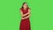 Tender girl in red dress girl froze and trying to keep warm. Green screen