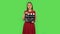 Tender girl in red dress is holding a movie in her hands. Green screen