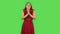 Tender girl in red dress is keeping palm together and asking for something. Green screen