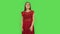 Tender girl in red dress is making sign ok. Green screen