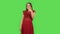 Tender girl in red dress is showing thumbs up, gesture like. Green screen