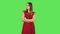 Tender girl in red dress is very offended and looking away. Green screen