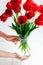 Tender hands hold tulips bouquet, selective focus