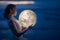 Tender image of a girl. Female magic. Beautiful attractive girl on a night beach with sand hugs the moon, art photo. On a dark