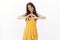 Tender lovely beautiful young girlfriend in stylish yellow dress, show heart sign and smiling caring, say i love you