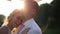 Tender moment of embracing between young couple on wedding day. Bride and groom with balloons on the bridge on sunset