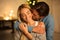 Tender moment. Man kissing wife in front of Christmas tree