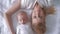 Tender moments, happy parent with newborn baby lying on the bed, view top on little girl touches hair of mother