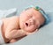 Tender newborn sleeping with wreath on head