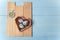 Tender pinwheel with bird and flowers, heart shaped box with decorated Easter eggs and brown boards on wooden blue background.