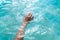 Tender touching surface of sea water. Woman`s hand touching surface of turquoise water in sunlight. Nature water concept, woman