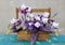 Tender white irises with purple lupins in a wooden crate.  Beautiful exquisite bouquet on the green wooden table