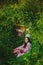 Tender woman resting in grassy thickets with a beautiful bouquet