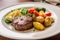 tenderloin steak, seared and juicy on the inside, topped with seasoned potatoes and vegetables