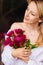 tenderness. a blonde woman in a white shirt and a bouquet of peonies.