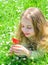 Tenderness concept. Girl on calm face holds red tulip flower on sunny spring day. Girl with long hair lying on grassplot
