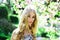 Tenderness concept. Girl on dreamy face, tender blonde looks at camera, nature background, defocused. Young woman enjoy