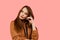 Tenderness and sensuality of a girl in a brown oversized suit on a pink background. Lifestyle. Cute and gentle young