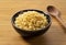 Tenkasu and wooden spoon served in a bowl placed on a wooden background