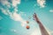 Tennis ball falls down from the hand. Against the sky. Summer fun concept