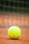 Tennis ball lies on the clay court close up