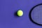Tennis ball and racket. Violet background. Concept sport.