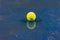 Tennis ball with reflection on ground after raining