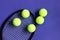 Tennis balls on black racket. Violet background. Concept sport.