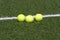 Tennis balls lays on grass court line