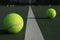 Tennis balls straddling the court line