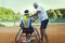 Tennis coach teaching a disabled player the backhand