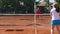 Tennis coach training her students on the tennis court