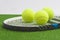 Tennis concept: closeup, tennis racket with balls lies on green
