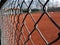 Tennis court in gravel viewed by the protective wire mesh