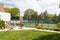 A tennis court in a park surrounded by a fence.