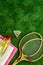 Tennis equipment - rockets, shuttlecock - on green grass background top-down frame copy space