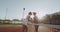 Before tennis game , two players women saying hello and holding hands before starting the game.