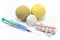 Tennis and golf ball with a syringe and pills