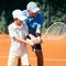 Tennis Lesson. Smiling Coach Explaining Tennis Technique to a Boy