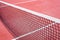 The tennis net on the background of the court is red. The theme of sports and a healthy lifestyle.