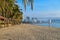 Tennis net on a sandy beach with palm trees and sea in the morning