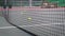 tennis net on the tennis court. yellow tennis balls fall into the net and the net sways