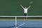 Tennis player man winning match happy excited with arms up in success on green outdoor court