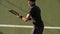 Tennis player practicing forehands strokes on court